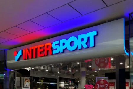 Red and blue illuminated Intersport letters above a store entrance. Red and blue illuminated Intersport letters above a store entrance.