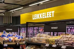 Valkoinen Leikkeleet-teksti keltaisessa opasteessa leipähyllyjen ja kylmäkaappien yläpuolella