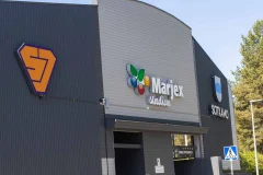 Marjex logo and other company signs on the facade of a grey industrial building