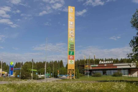 Hög gul ABC-reklampylon med servicesymboler bredvid en S-market