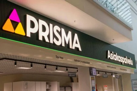 Illuminated Prisma logo and Asiakaspalvelu lettering above a customer service desk