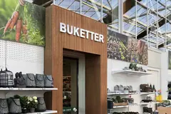 White Buketter lettering at the top of a wood-effect portal in a flower section