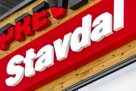 White Stavdal letters on a red background on a wooden facade.