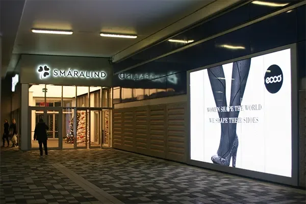 Large illuminated advertising screen beside the entrance to Smáralind shopping centre