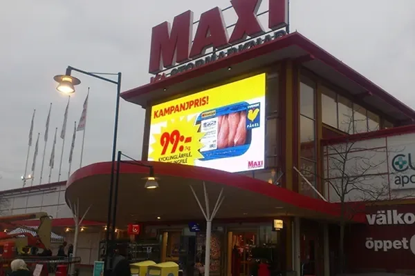 Large digital promotional screen above an ICA Maxi store entrance