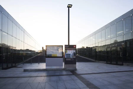 Two low map and information boards on a walkway between glass-walled buildings. Two low map and information boards on a walkway between glass-walled buildings.
