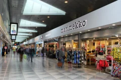 Marimekko lettering above a store entrance along a busy indoor walkway. Marimekko lettering above a store entrance along a busy indoor walkway.