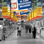 Colourful promotional signs above a store aisle in an otherwise black-and-white photograph. Colourful promotional signs above a store aisle in an otherwise black-and-white photograph.
