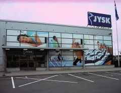 Large window graphics on a JYSK facade show bedding and home furnishings. Large window graphics on a JYSK facade show bedding and home furnishings.