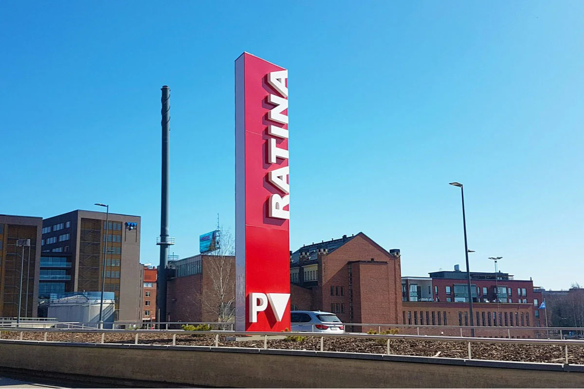 Korkea punainen Ratina-pyloni tien varrella sinistä taivasta vasten