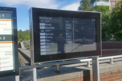 Ulkotilan digitaalinen näyttö esittää joukkoliikenteen määränpäitä ja odotusaikoja.