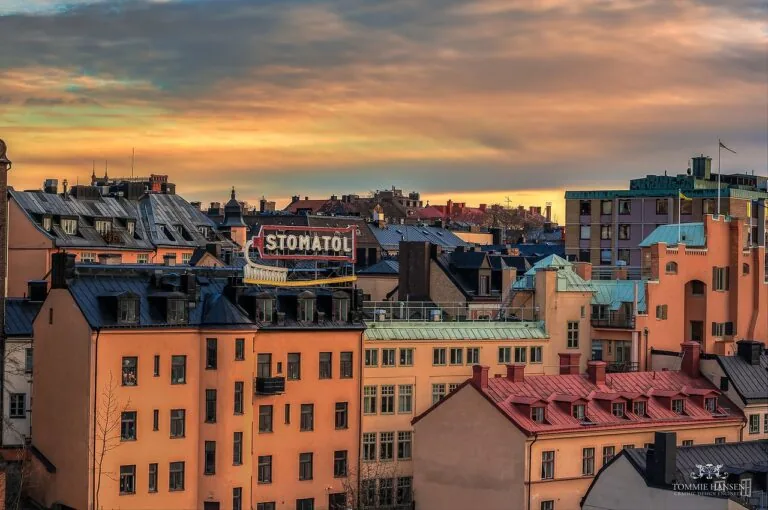 Stomatol sign above rooftops in Slussen, Stockholm, at sunset
