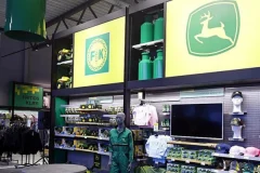 John Deere -logolla varustettu myymäläseinä sekä vaatteita ja oheistuotteita hyllyissä