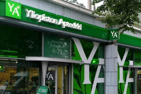 Green Yliopiston Apteekki facade sign and large white-and-green window graphics