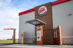 A round Burger King sign on a grey facade above the restaurant entrance.