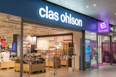 Valaistu Clas Ohlson -nimi avoimen myymälän sisäänkäynnin yläpuolella.