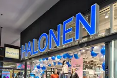 Large blue illuminated Halonen letters above a shop entrance