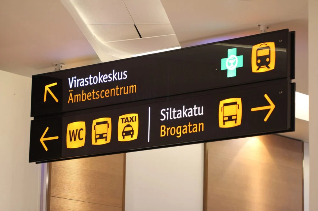 Suomen- ja ruotsinkielinen katto-opaste ohjaa Virastokeskukseen, Siltakadulle, wc-tiloihin ja liikennepalveluihin.
