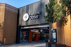 A Helsinki Outlet sign and H logo above a wood-clad entrance.