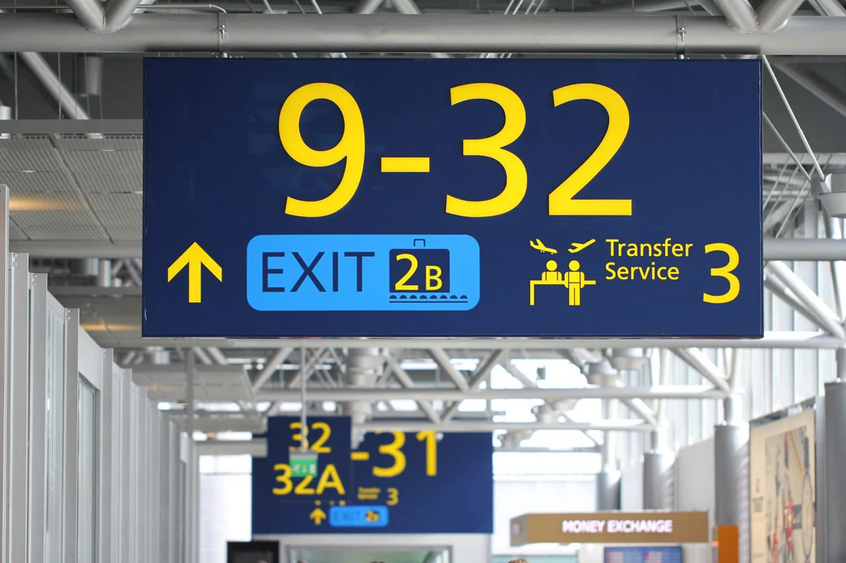 Sininen katto-opaste näyttää portit 9–32, uloskäynnin 2B ja Transfer Service 3:n.