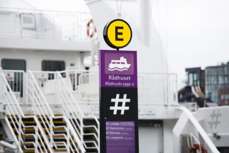 Rådhusetin violetti laituripylväs ja keltainen E-tunnus lautan vieressä.