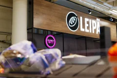 Valaistu Leipä-teksti ja pyöreä leipäsymboli puukuvioisessa opasteessa Prisma Sellossa