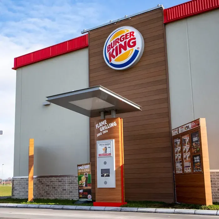 A round illuminated Burger King sign above a restaurant entrance.
