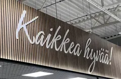 White Kaikkea hyvää lettering on a vertically slatted wall in a grocery store White Kaikkea hyvää lettering on a vertically slatted wall in a grocery store