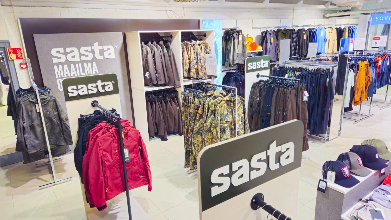 Sastan vaaterekkejä, seinäkalusteita ja logokylttejä myymälässä