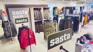 Sastan vaaterekkejä, seinäkalusteita ja logokylttejä myymälässä