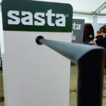Sastan vaaterekin pääty Sasta-logo vaaleassa vaaterekin päädyssä mustan ripustustangon yllä