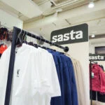 Sasta-opaste valkoisten ja sinisten paitojen vaaterekin yläpuolella