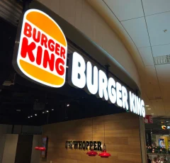 Illuminated Burger King logo and white lettering at a restaurant entrance