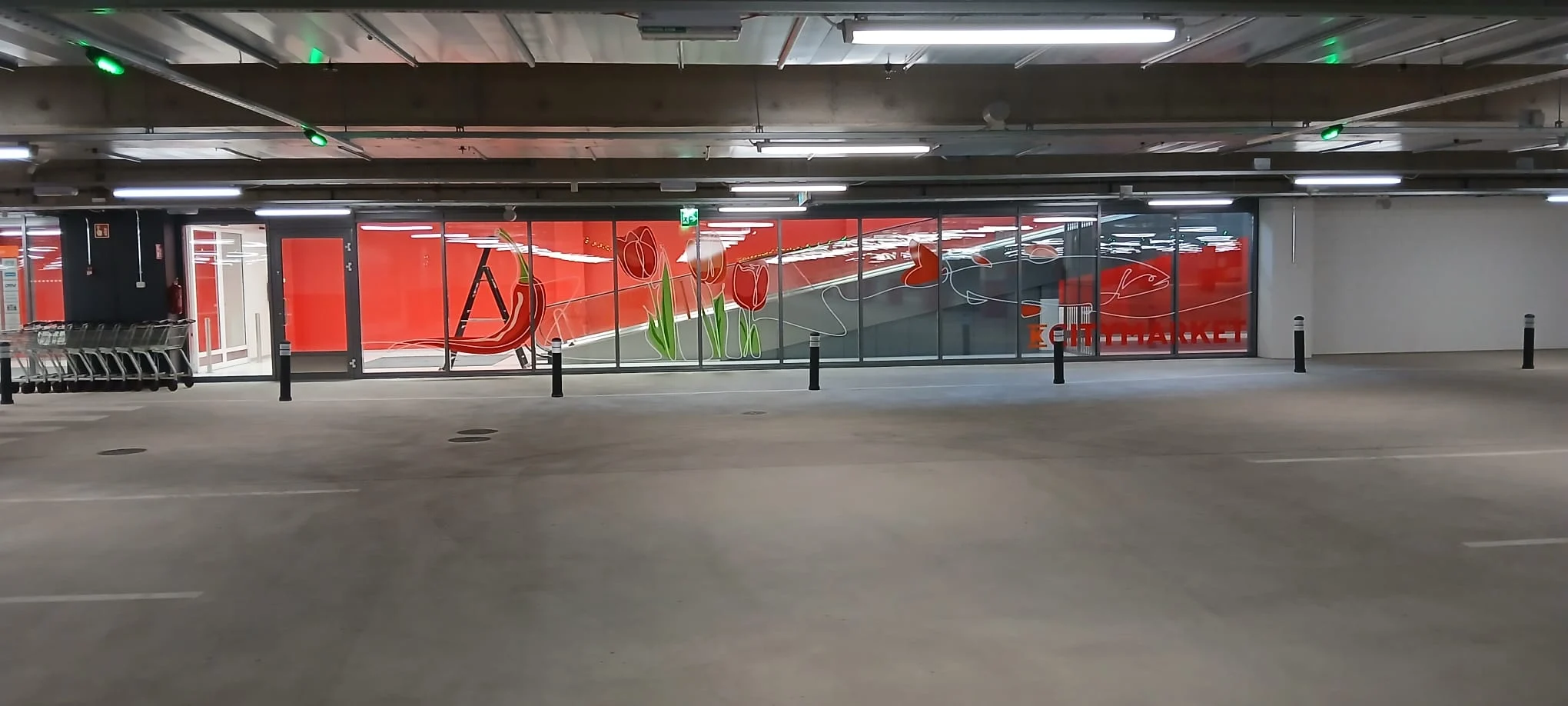 Punaiset kuvioteippaukset K-Citymarket Haapaniemen pysäköintihallin lasiseinällä