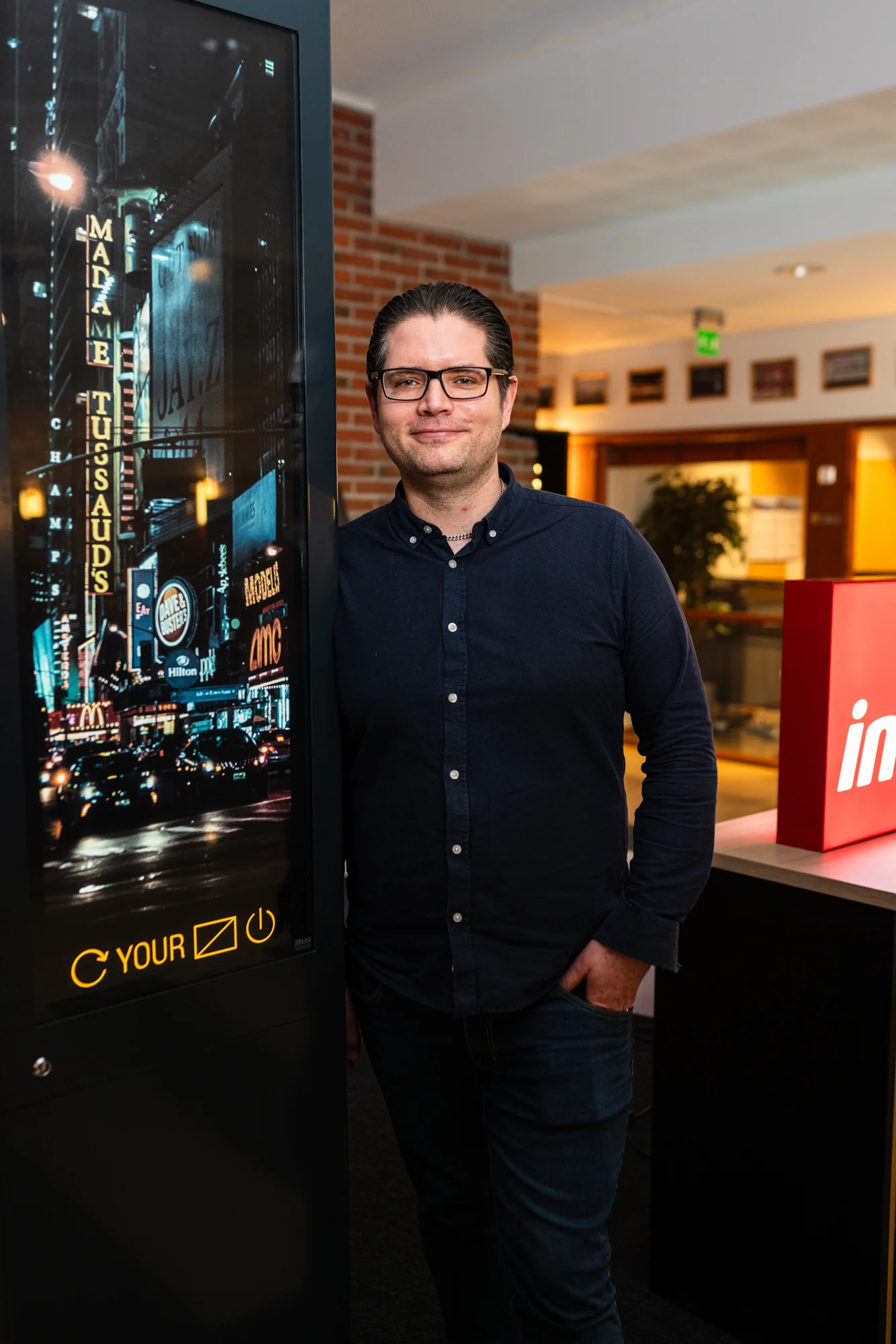 Tapio Rissanen korkean digitaalisen näytön vieressä