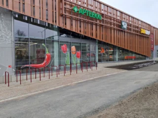 Red plant-themed graphics on the glass facade of K-Citymarket Haapaniemi