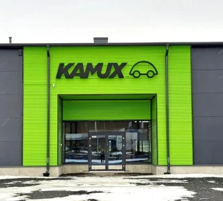 Kamux-logo autoliikkeen sisäänkäynnin yläpuolella Lakalaivassa