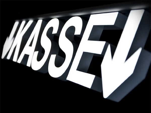 Illuminated KASSE lettering and a downward arrow on a black background.